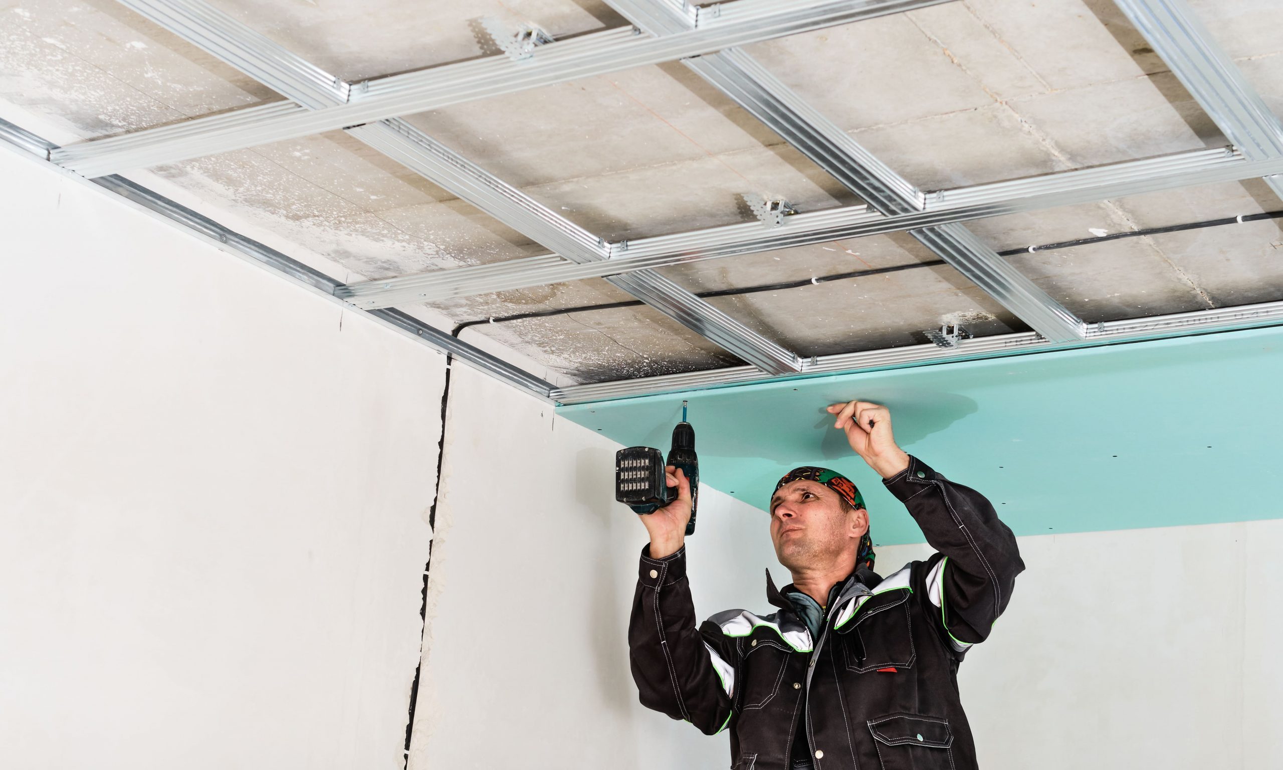 Worker installing ceiling panels